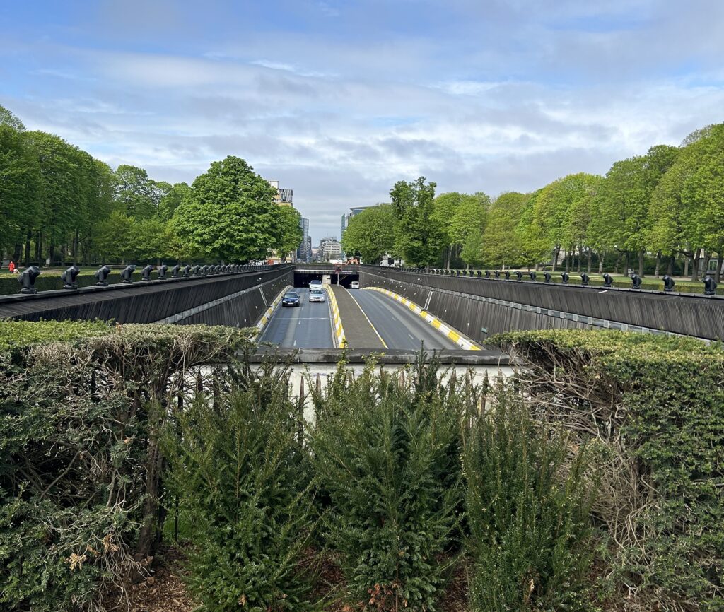 Cinquantenaire Park i Brussel der veien er senket ned, uten behov for høye murer som støyskjerm, men der naturen selv gjør jobben. Det er helt i tråd med prinsippene i NEB: Vakkert, bærekraftig, inkluderende.